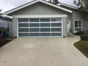 White aluminum full-view garage door with frosted glass on grey ranch-style home San Diego